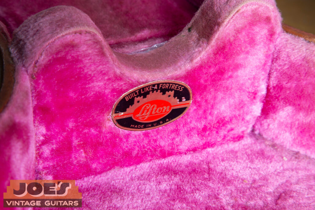 Macro close-up of the small metal Lifton brand plate on the exterior of a 1956 "California Girl" hardshell case.