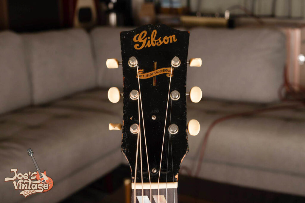 Close-up of a 1944 Gibson Southern Jumbo (SJ) headstock featuring the rare wartime gold Banner logo "Only a Gibson Is Good Enough" and the classic script Gibson logo.